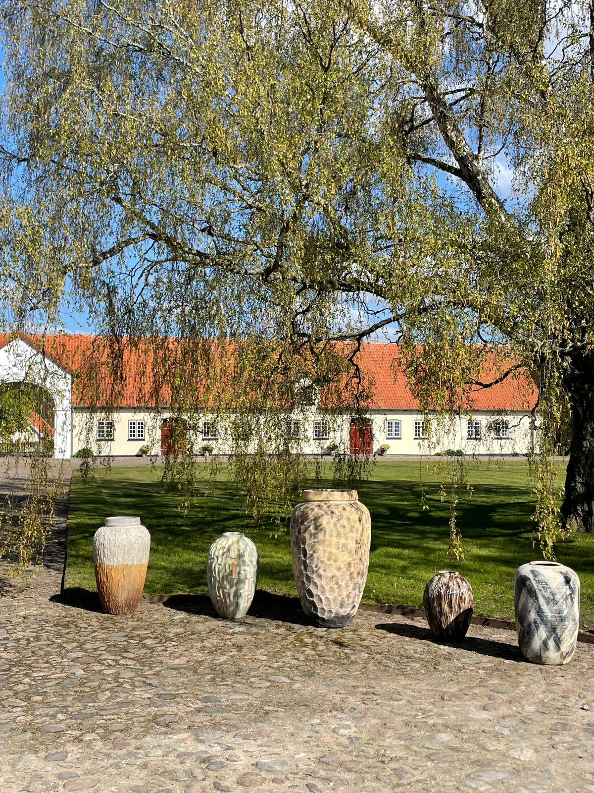 Store keramiske vaser foran en dansk landejendom