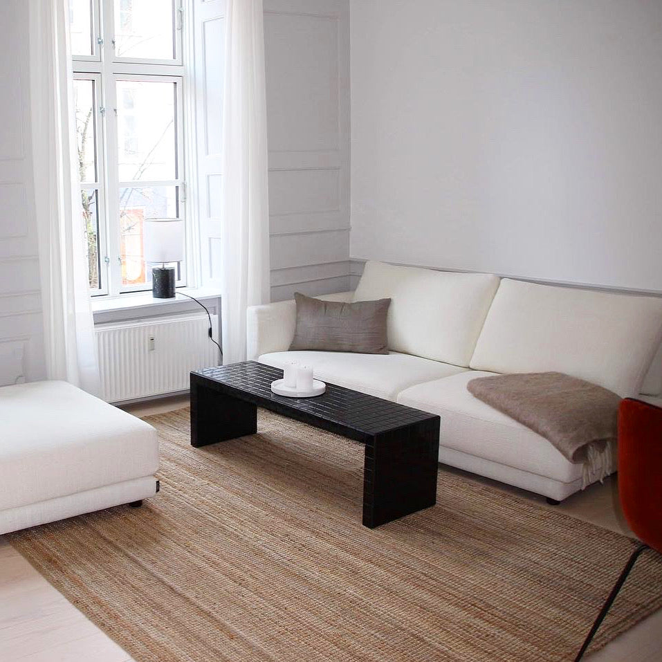 Lys stue med sort klinkesofabord